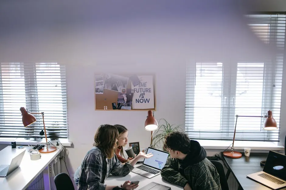 Modern Business consultants discussing strategy around laptops in a bright office