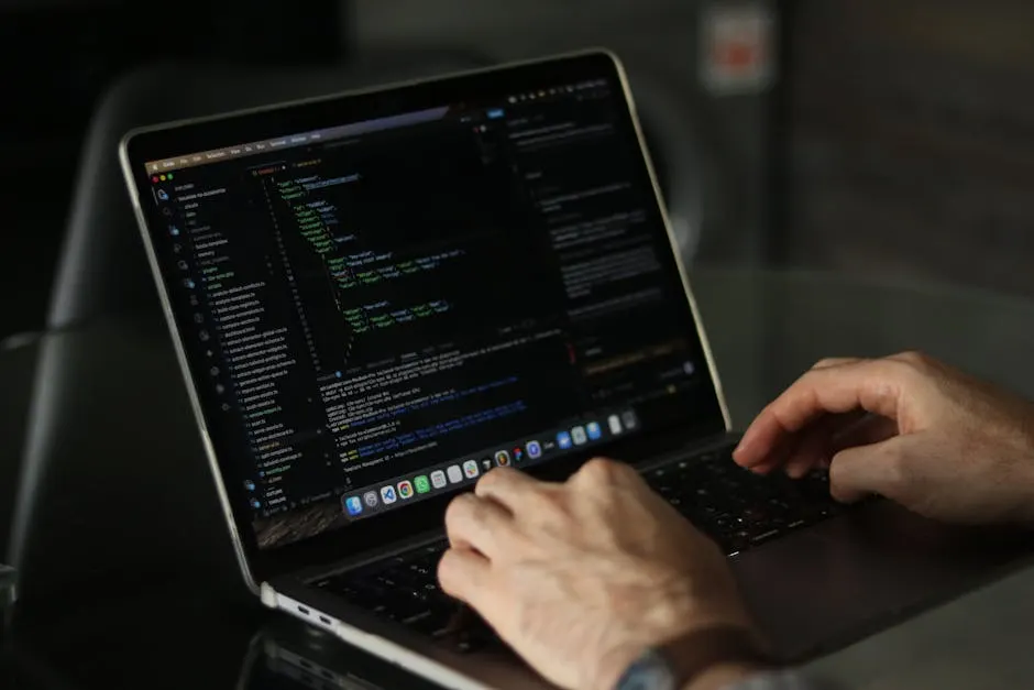 Close-up of hands writing SQL queries on a laptop